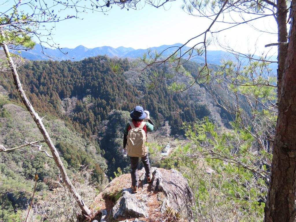 三の鎖を登ってすぐの岩の上で景色を眺める娘