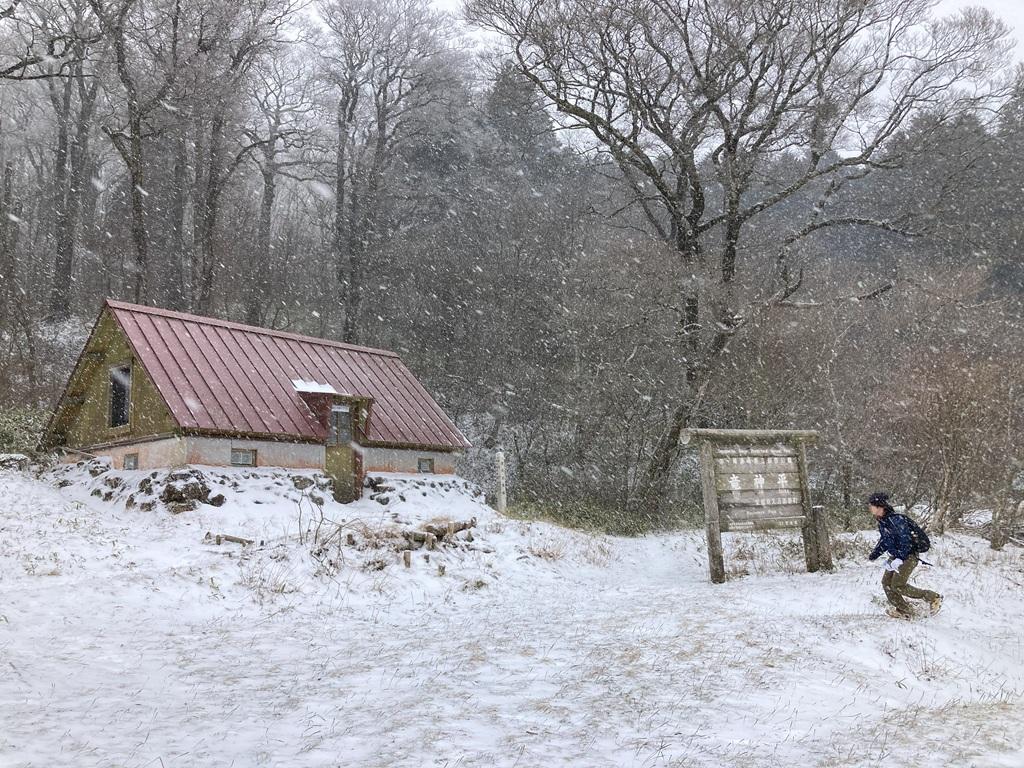 吹雪の中、竜神平の標識から山小屋に向かって走る娘